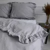 A close-up view of a gray duvet cover with ruffles on a bed. Produktbild-Vorschau