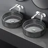 Two modern glass washbasins with chrome faucets mounted on a gray wall above a ribbed cabinet. Anteprima dell’immagine prodotto