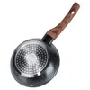 The underside of a frying pan with a wooden handle, shown against a white background. Podgląd zdjęcia produktu