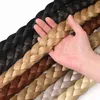 Eine Hand, die eine blonde geflochtene Haarverlängerung hält, mit anderen geflochtenen Verlängerungen in verschiedenen Schwarztönen, Brauntönen und Blondtönen darunter aufgefächert Náhľad obrázku produktu