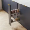 A pull-out spice rack with glass jars filled with spices is shown inside a dark gray kitchen cabinet. Podgląd zdjęcia produktu
