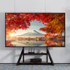 A TV stand with a large screen displaying a scenic landscape is shown in a room. Produktbild-Vorschau
