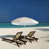 Two lounge chairs and a beach umbrella on a sandy beach with the ocean and blue sky in the background. Produktbild-Vorschau