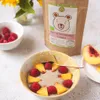 A bowl of oatmeal with raspberries and peaches, a bag of Helpa cereal, and a vase of sunflowers. Podgląd zdjęcia produktu