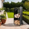 A black metal log holder filled with firewood is placed on a paved patio next to a white house and a manicured lawn. Náhled obrázku produktu