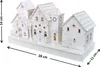 A white, illuminated Christmas village scene with multiple houses, trees, and figures, displayed on a white base. Podgląd zdjęcia produktu
