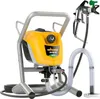 A yellow and gray electric paint sprayer with a black hose and a green nozzle, set against a white background. Náhled obrázku produktu