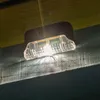 A solar-powered light fixture is mounted on a wooden beam, illuminating downwards. Produktbild-Vorschau