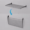 A wall-mounted drying rack is shown in two states: extended and folded down, with an arrow indicating the folding action. Voir les images du produit