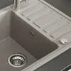 A close-up view of a beige kitchen sink with a chrome faucet and drain. Anteprima dell’immagine prodotto