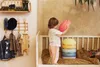 A young child is playing with colorful stacking stones in a nursery. Anteprima dell’immagine prodotto
