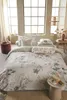 A beautifully made bed with floral patterned bedding in a bright, airy bedroom. Produktbild-Vorschau