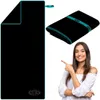 A woman points to a folded black microfiber towel with teal trim. Náhľad obrázku produktu