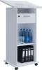 A white mobile lectern with a tilted top surface, a drawer, and shelves containing water bottles, glasses, and binders, all on a white background. Podgląd zdjęcia produktu