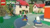 A scene from the video game LEGO Worlds, featuring Lego vehicles driving on a road in a Lego-built town. Produktbild-Vorschau