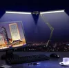A desk setup at night with a computer monitor, keyboard, mouse, and a desk lamp. Produktbild-Vorschau