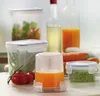 A collection of food storage containers and fresh produce arranged on a countertop. Produktbild-Vorschau