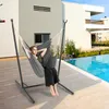 A woman relaxing in a hammock chair next to a swimming pool. Náhled obrázku produktu