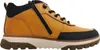 A side view of a brown leather boot with black accents and a white sole. Voir les images du produit