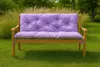 A purple cushioned bench sits on a green lawn with tall grasses and trees in the background. Anteprima dell’immagine prodotto