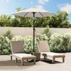 Two lounge chairs and a patio umbrella are set up on a paved patio area with lush green bushes and a wooden fence in the background. Anteprima dell’immagine prodotto