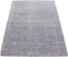 A shaggy, grey rug is shown from a diagonal, slightly elevated angle against a white background. Produktbild-Vorschau