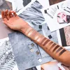 A person's arm with eyeshadow swatches on it, surrounded by makeup-related imagery and product packaging. Produktbild-Vorschau