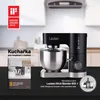 A black stand mixer is featured prominently on a dark surface, with a kitchen scene blurred in the background. To the left is an open book or pamphlet, and to the right is a circular graphic showing blender attachments. Náhled obrázku produktu