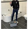 A person is standing in a bathroom holding a mop and bucket. Produktbild-Vorschau