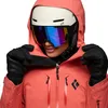 Dame trägt die Recon Stretch LT Shell Jacke von Black Diamond in Korallenfarbe; mit Handschuhen und Skihelm; bereit für den Wintersport. Produktbild-Vorschau