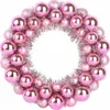 A wreath made of pink and silver Christmas ornaments. Voir les images du produit
