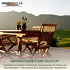A wooden table and chairs set on a deck with a mountain and green field in the background. Produktbild-Vorschau