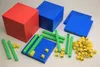 A collection of math manipulatives, including base-ten blocks of different sizes and colors, arranged on a light gray surface. Anteprima dell’immagine prodotto