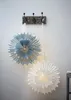 Two paper star lanterns hanging on hooks on a wall. Podgląd zdjęcia produktu