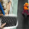 A collage showing a person walking on a rubber mat in an industrial setting, with a close-up of the mat's texture and a background of stacked pallets and materials. Podgląd zdjęcia produktu