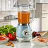 A vintage-style blender in a kitchen setting, surrounded by fresh ingredients and prepared food. Anteprima dell’immagine prodotto