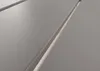 A close-up view of a gray surface with parallel grooves, possibly a table or furniture. Produktbild-Vorschau