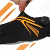 A close-up shot of a hand stretching a black and orange sports glove. Podgląd zdjęcia produktu