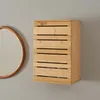 A wooden cabinet mounted on a gray wall next to a round mirror. Podgląd zdjęcia produktu