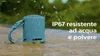 A small blue Bluetooth speaker is shown outdoors with water splashing around it. Voir les images du produit