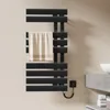A black electric towel warmer mounted on a light-colored wall, with a beige towel draped over it. Náhľad obrázku produktu