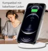A woman is writing in a notebook while a smartphone is charging wirelessly on a stand. Anteprima dell’immagine prodotto