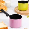 Two small saucepans, one pink and one green, are displayed on a countertop with some bread and a glass of milk in the background. Náhled obrázku produktu