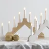A close-up shot of two candle holders with lights on, placed on a white tablecloth with gold ornaments. Podgląd zdjęcia produktu