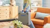 A person is holding a Dremel tool case in a living room setting. Produktbild-Vorschau