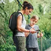 A woman and a child are looking at a smartphone while hiking. Produktbild-Vorschau