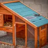 A solar-powered fan and solar panel are mounted on the roof of a wooden chicken coop. Produktbild-Vorschau