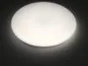 A round, white ceiling light with a glitter effect, shown against a dark background. Produktbild-Vorschau