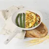 A cooking pan with food and asparagus on a wooden board, with a cloth and wheat stalks in the background. Produktbild-Vorschau
