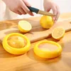 A person is cutting a lemon on a wooden cutting board, with yellow lemon-shaped food containers in the foreground. Produktbild-Vorschau